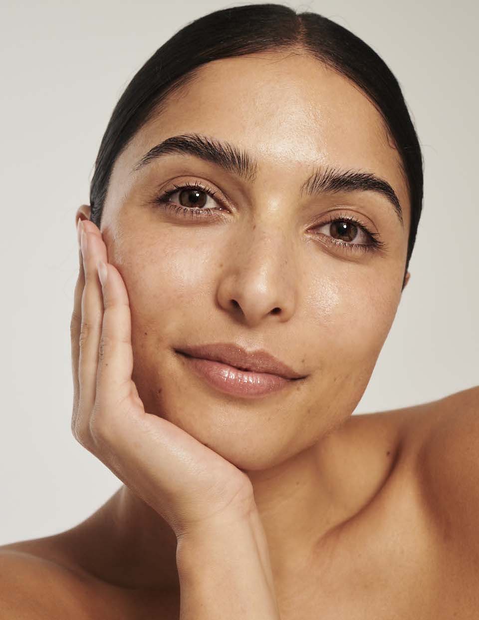 Girl wearing face tan serum to show golden skin